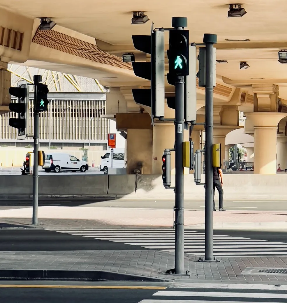 A signalised intersection and pedestrian crossing under an elevated road in Dubai (illustrative only; not Al Satwa Roundabout itself)