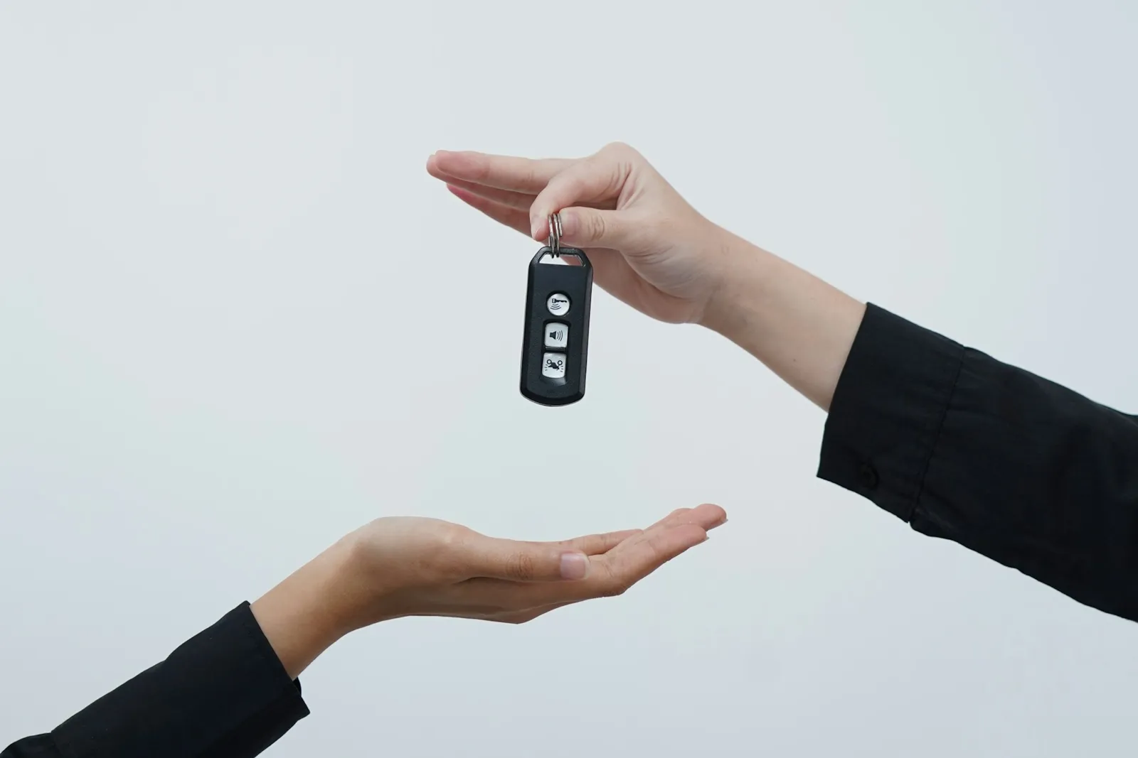鍵を手渡す手元。ドバイで車を売却して名義変更を終え、買い手に車を引き渡す場面のイメージ